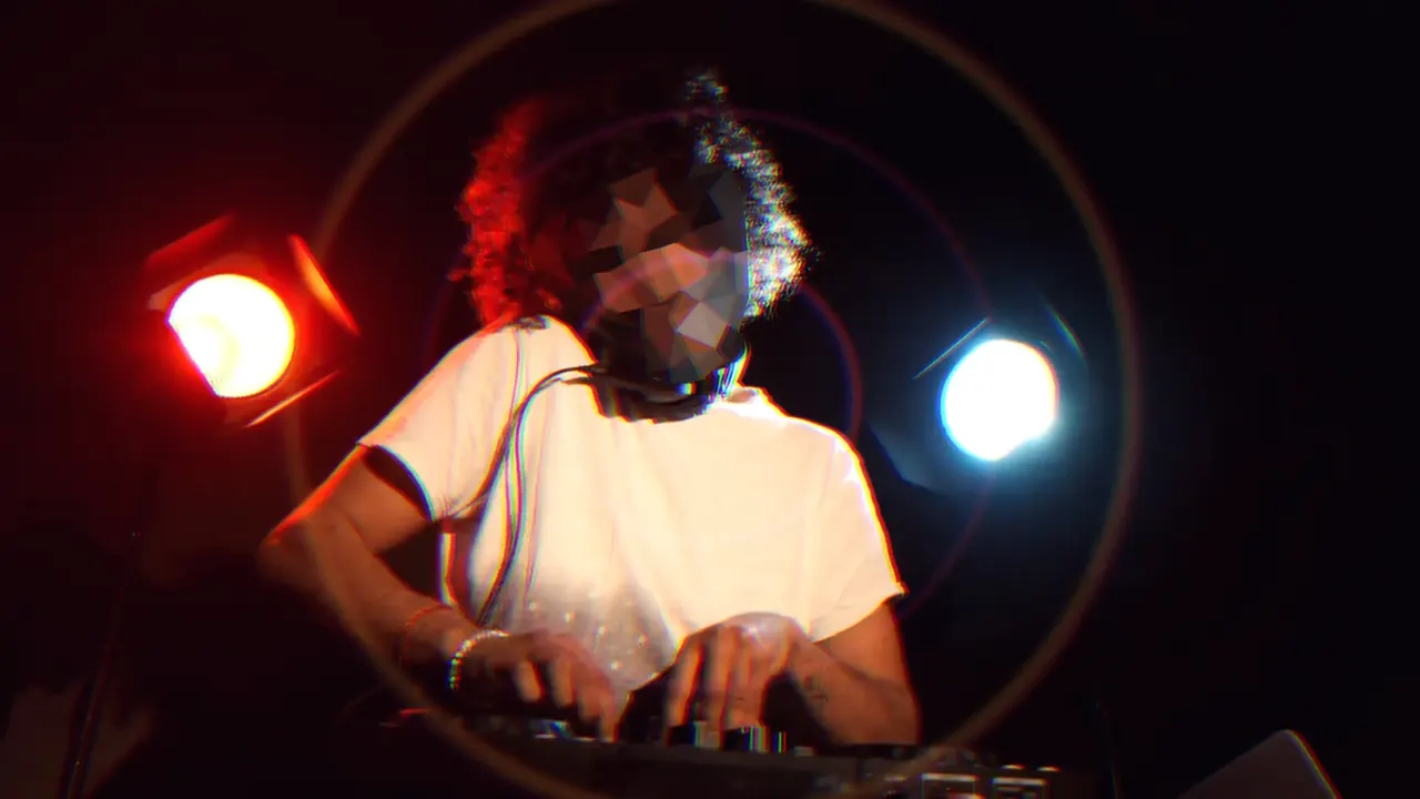 Just before the drop: the masked DJ under red and blue lights